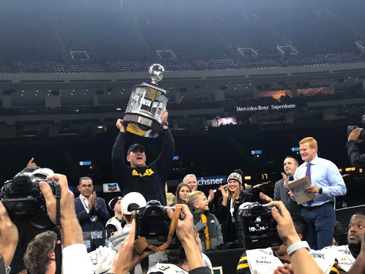 Head Coach Shawn Clark raises the New Orleans Bowl championship trophy